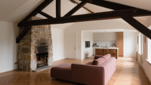 Duplex sous combles avec cheminée ancienne, poutres apparentes et lumière naturelle dans un intérieur rénové